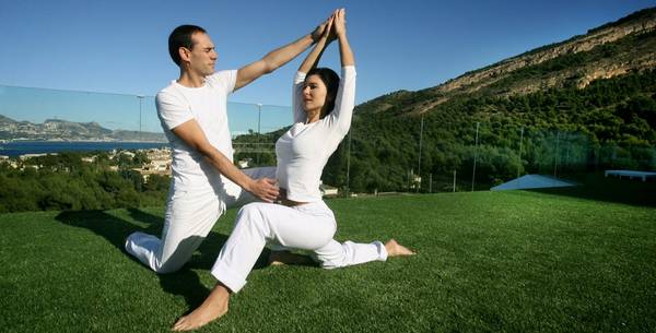 Pilates teacher guiding guest in pose at SHA Wellness Clinic