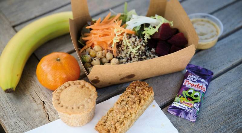 Group of hikers on a nature path, with their arms stretched out towards the sky, posing for the camera. 
