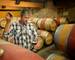 Winemaker getting sample of red wine from barrel