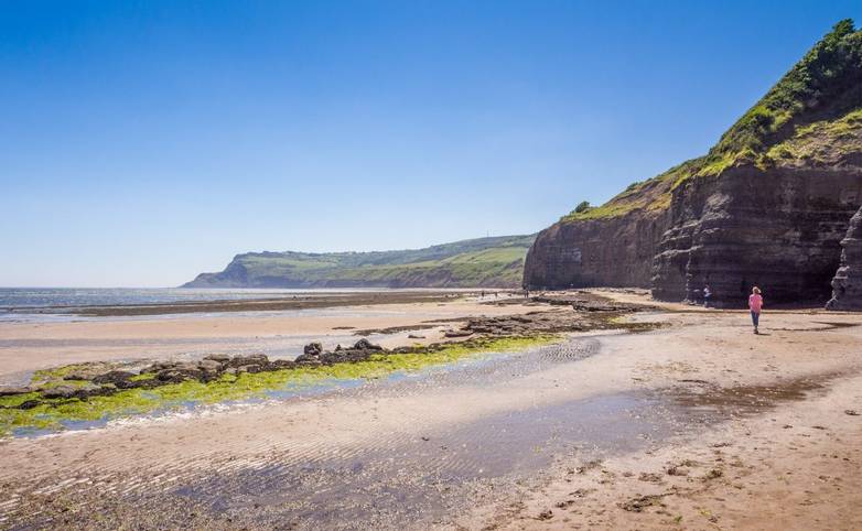 Robin Hoods Bay, Whitby, North Yorkshire, UK Holiday makers enjoying the golden sands at Robun Hoods Bay in the warm summer …