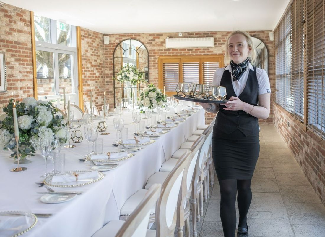 Wedding waiting staff helping set a wedding venue space for dinner