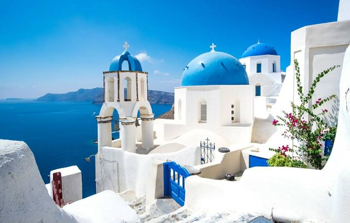 Scenic view of traditional cycladic white houses and blue domes in Oia village, Santorini island, Greece Scenic view of traditional cycladic white houses and blue domes in Oia village, Santorini island, Greece