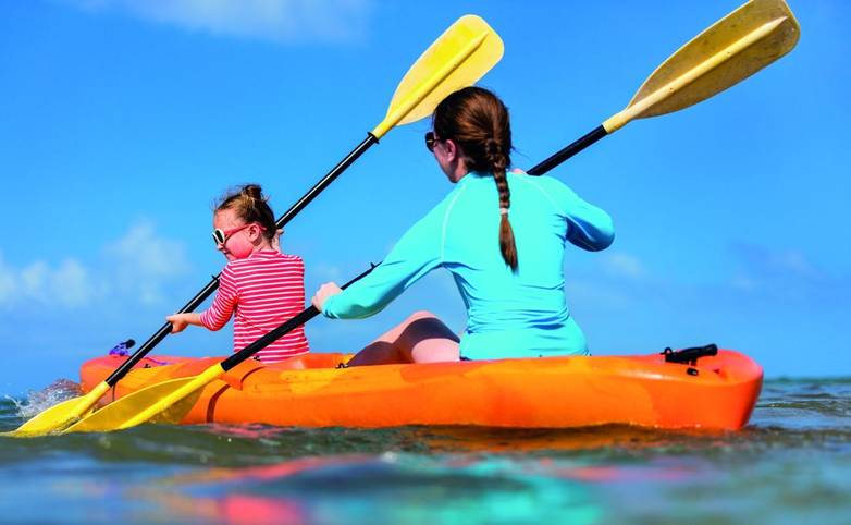 Family kayaking at tropical ocean