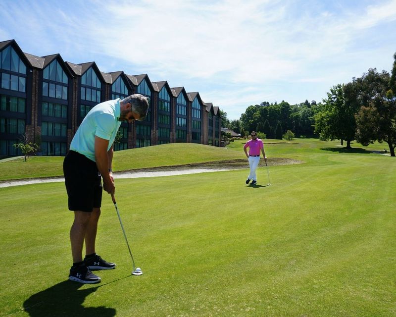 Golfers enjoy a round of golf by luxury apartments