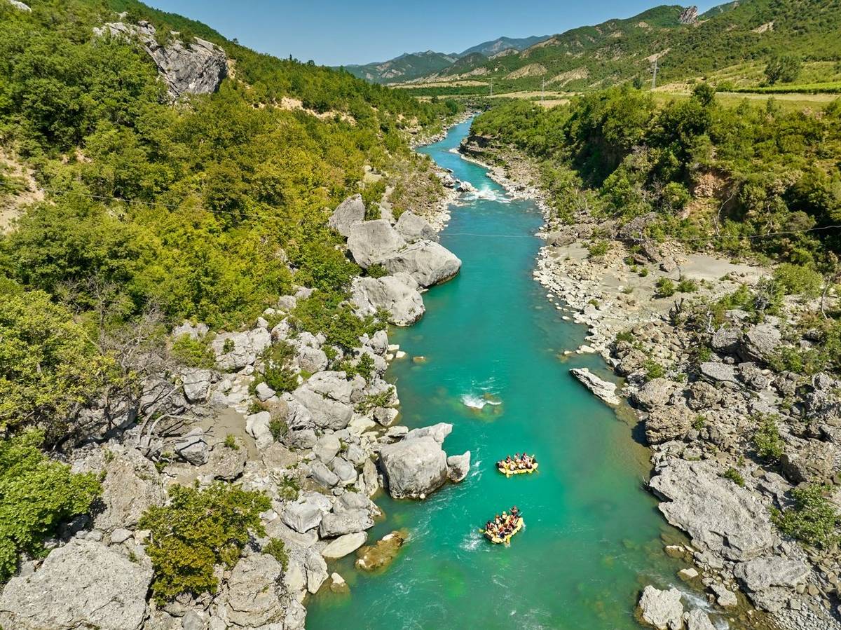 White water rafting.  Adventure and sport. A yellow raft floating among the rocks on the crystal clear, blue-green water. Pe…