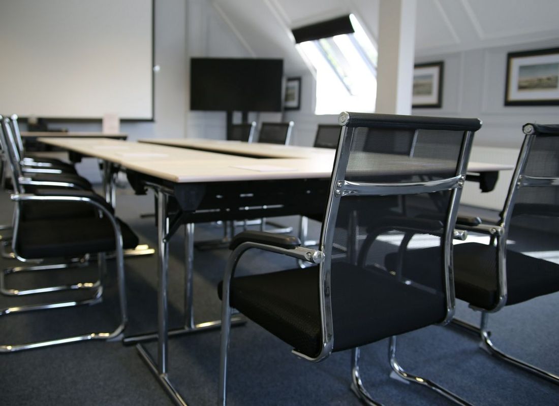 Small meeting room with projector and u shape table and chair layout