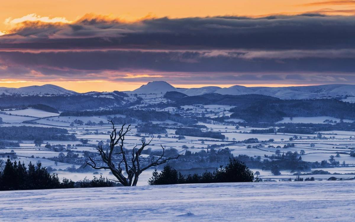 Sunset over Caer Caradoc in Shropshire Hills at winter in UK