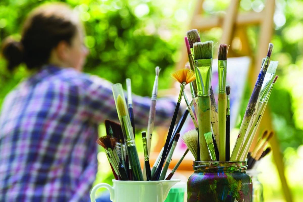 Frau beim Malen mit Pinseln, woman painting with paint brush