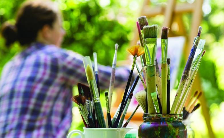 Frau beim Malen mit Pinseln, woman painting with paint brush