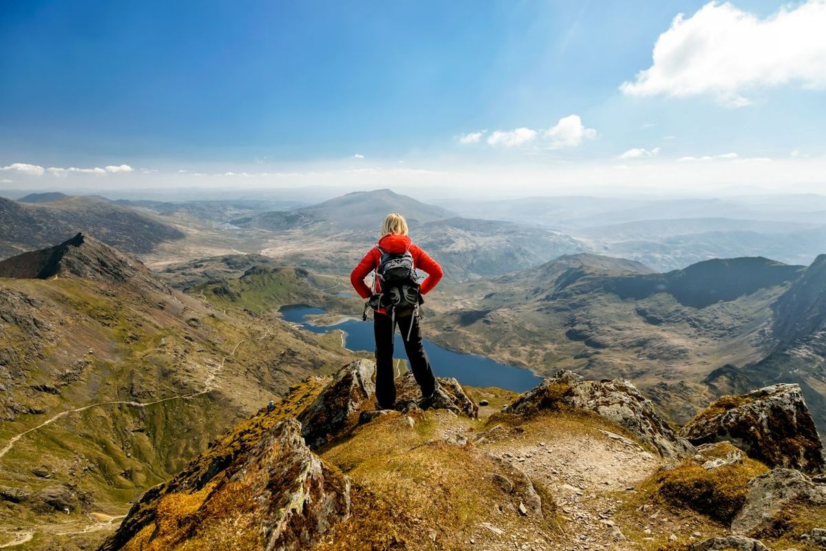 Summit views Snowdonia scenic mountain lake viewed by young female while on outdoor adventure vacation travel tourism Wales