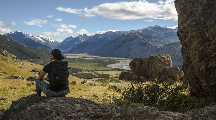 Woman wearing a backpack looking out at Patagonia's rugged landscape