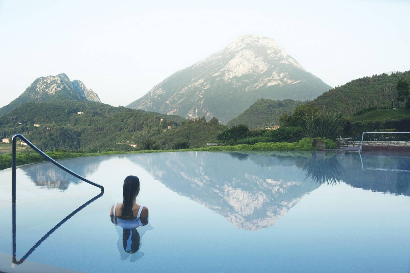 Woman in heated pool looking at the mountains at Lefay Resort in Lake Garda, Italy