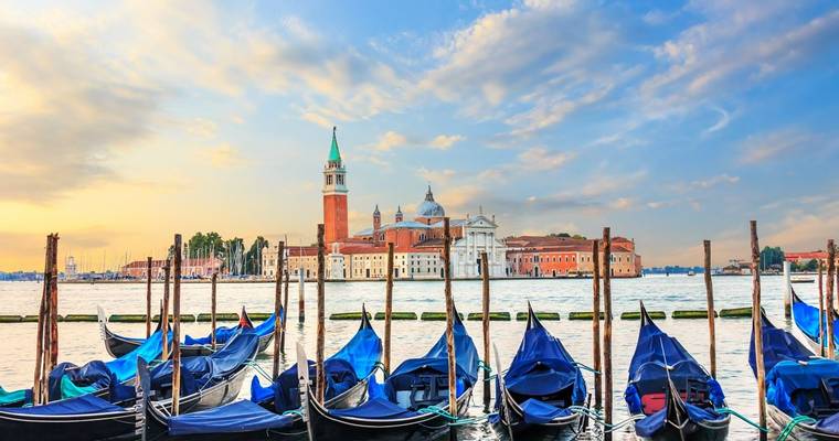 Gondolas moored at the pier in Grand Canal with San Giorgio Maggiore in the background, Venice, Italy.