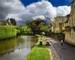 Ducks swimming on River Windrush in sunshine after a rain storm in Bourton-on-the-water Cotswold England