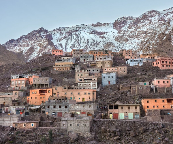 A mountain village nestled in the high Atlas Mountains, the tops of the mountains covered with snow