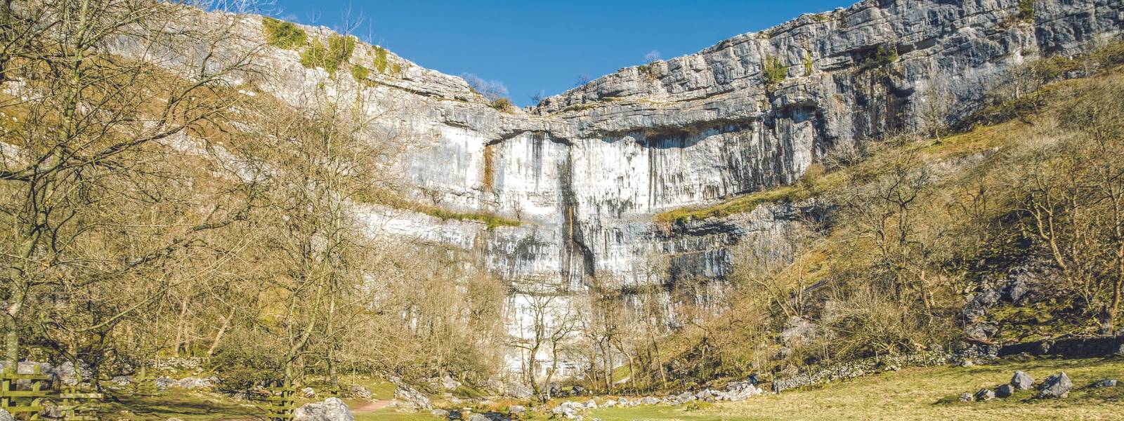 Limestone cliffs of Malham Cove in North Yorkshire, England on sunny day.