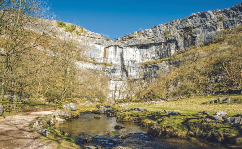 Limestone cliffs of Malham Cove in North Yorkshire, England on sunny day.