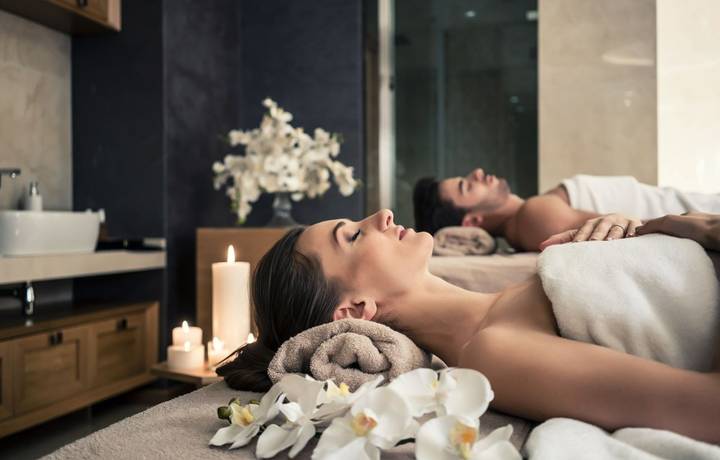Young man and woman lying down on massage beds at Asian luxury spa and wellness center Young man and woman lying down on massage beds at Asian luxury spa and wellness center