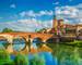 Panoramic view to Bridge Ponte Pietra in Verona on Adige river, Veneto region, Italy. Sunny summer day panorama and blue dra…