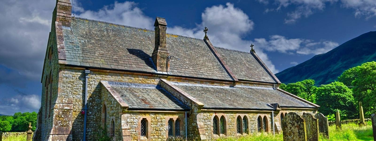 A wide angle view of an ancient stone church in Bassenthwaite, Cumbria, England.