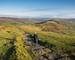 Woman walking the stone path from Mam Tor to Hollins Cross near Castleton in the Peak District, Derbyshire, UK.