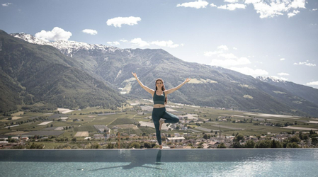 A woman doing Yoga over a mountain view in Italy 