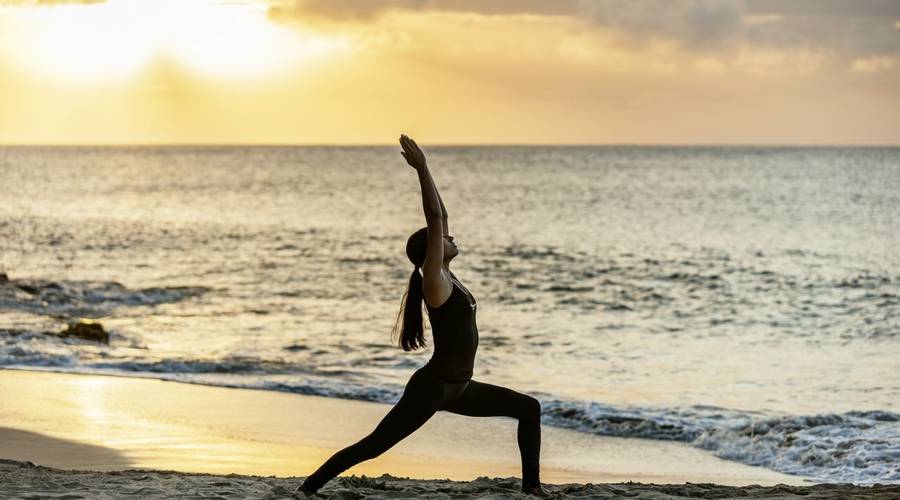 Woman doing yoga on the beach during a detox spa retreat