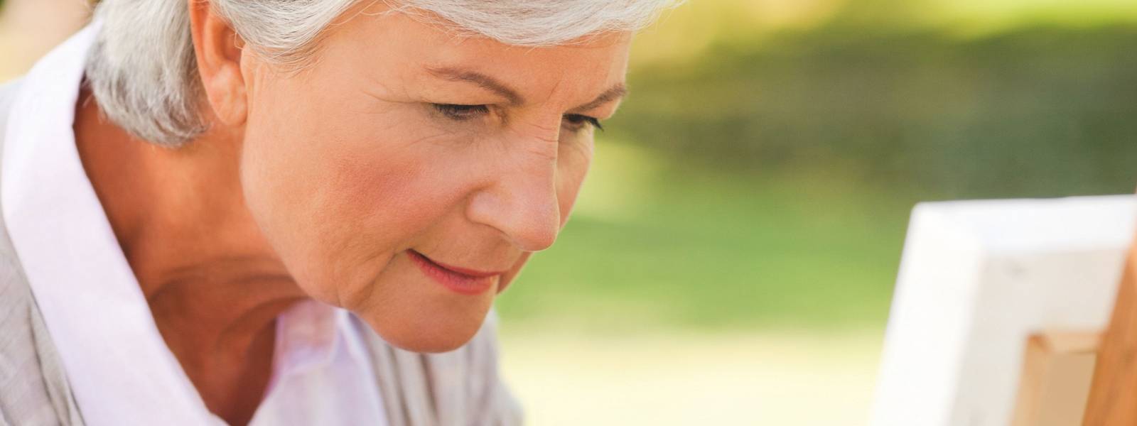 Mature woman painting in the park