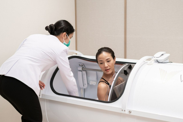 Woman being helped into a hyperbaric chamber at RAKxa Wellness and Medical Retreat in Thailand