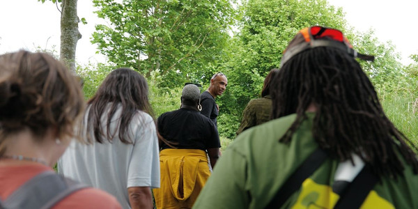 Group photo of 30+ HF Holidays guests, posing for the photo with a large green banner that reads 'HF Holidays: Walk Your Way'