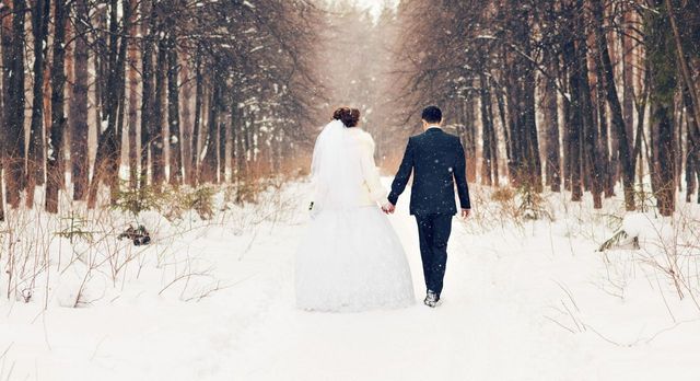Wedding couple walking down winter countryside