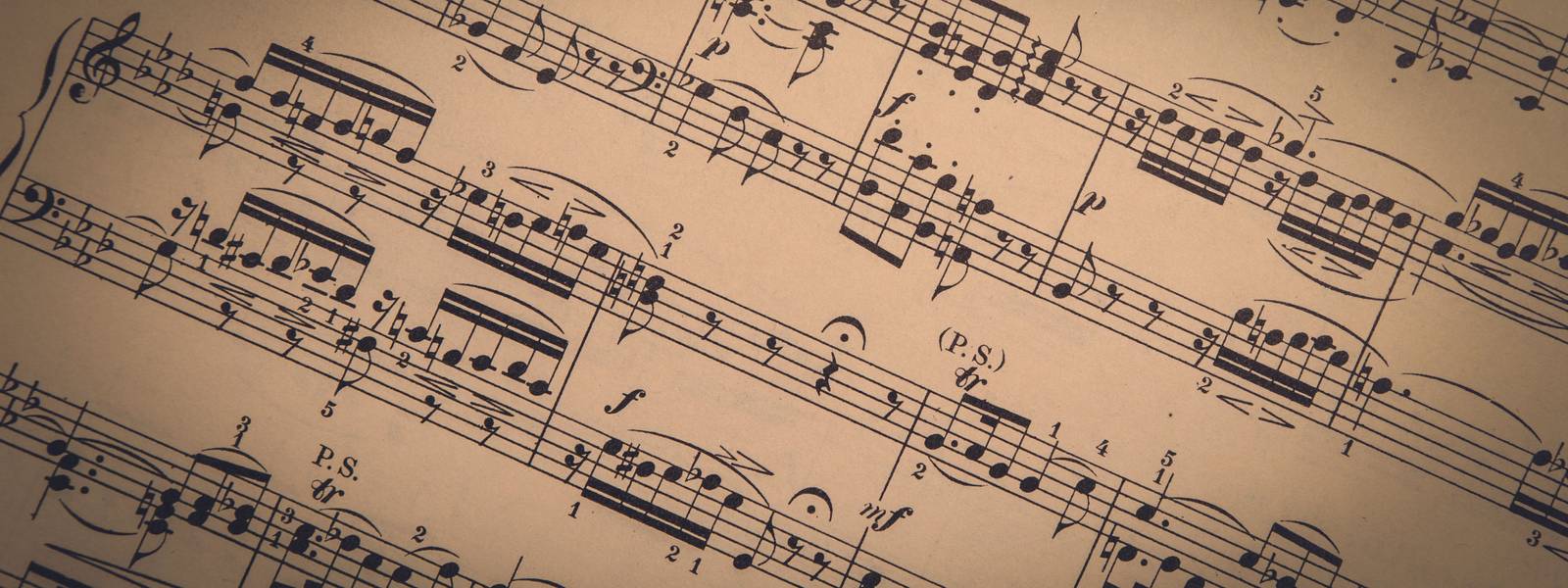 Old classical sheet music has a vintage tone and texture to it; panoramic format