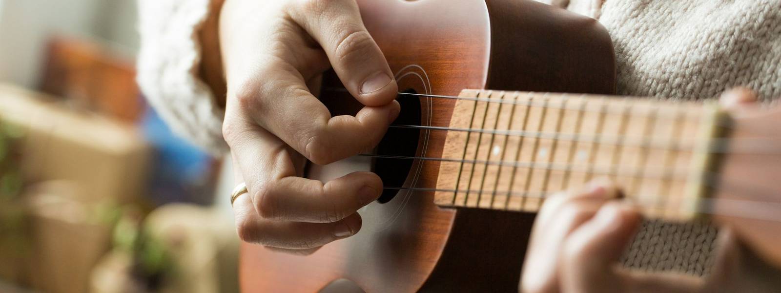 Close up of woman playing ukulele.