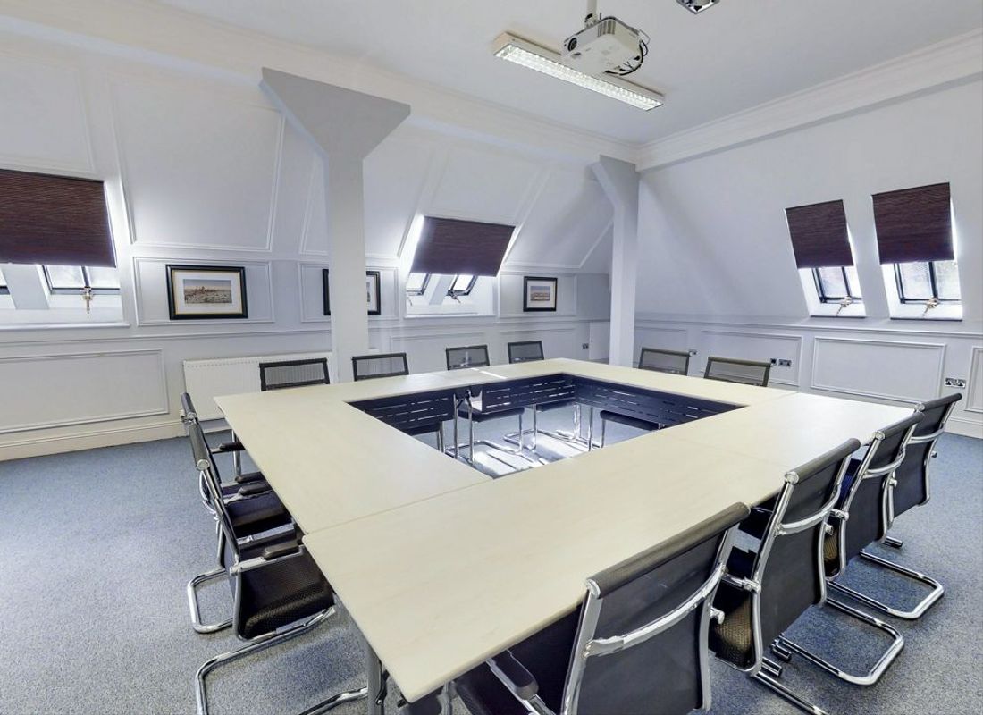 Large meeting room with chairs and tables set up in a square