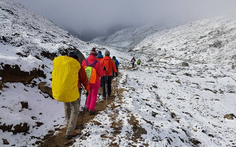 Group of trekkers hiking through snow covered valley at Everest Base Camp, Nepal