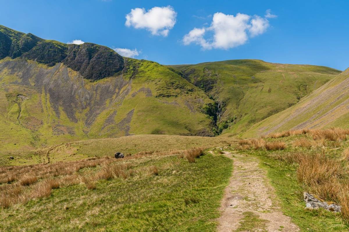 A footpath in the Howgill Fells with Cautley Spout in the background, near Low Haygarth, Cumbria, England, UK