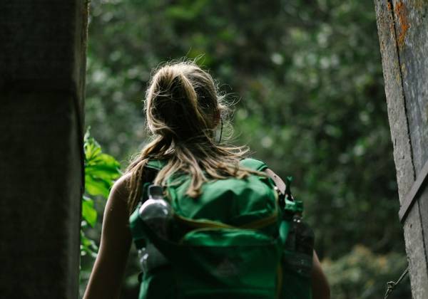Woman with a backpack entering the woods