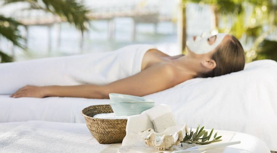 Woman relaxing on a lounger with a face mask at Marbella Club in Spain