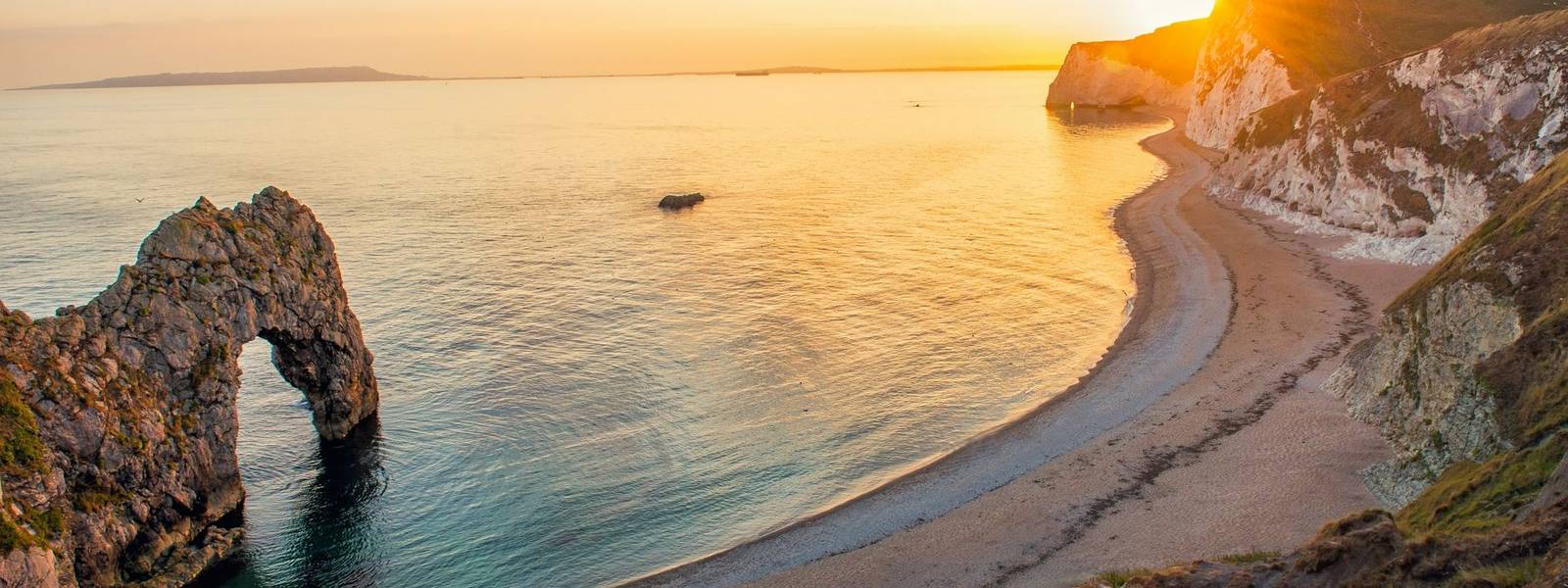 Landscape of empty Durdle Door beach at Sunset. Dorset England.
