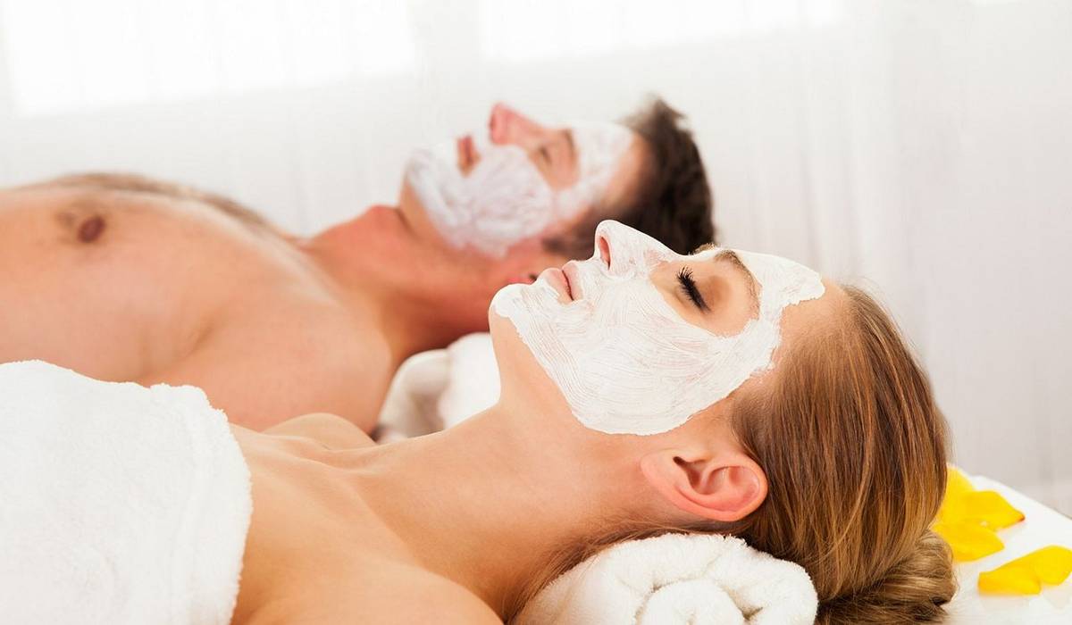 17260977 - man and woman in face masks lying back on clean white towels in a spa relaxing