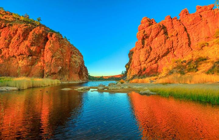 Northern Territory, Australian Outback. Scenic Glen Helen Gorge in West MacDonnell Ranges changes colours with sunrise light…
