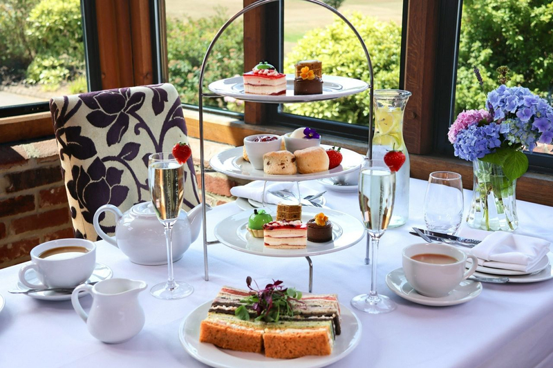 Three tiers of afternoon tea with a glass of Prosecco