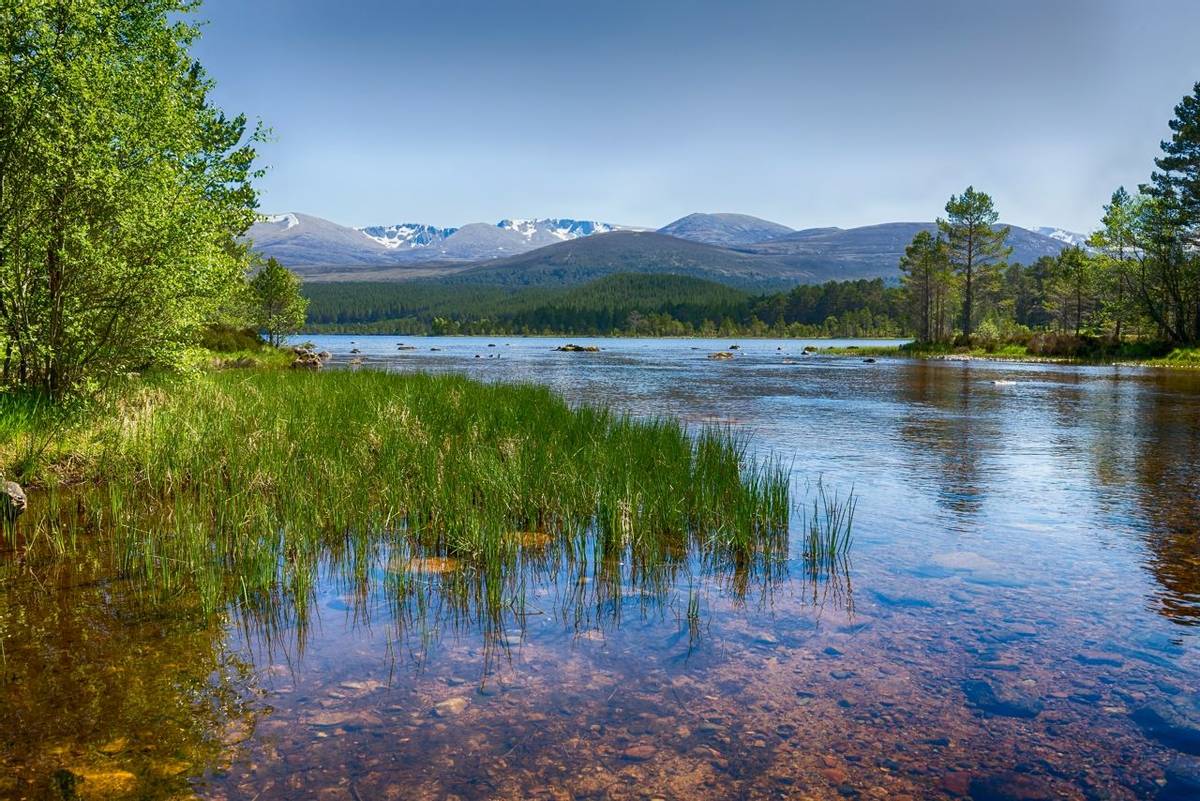 The clear waters of Loch Morlich, Scotland.  The Cairngorm mountains in the background.