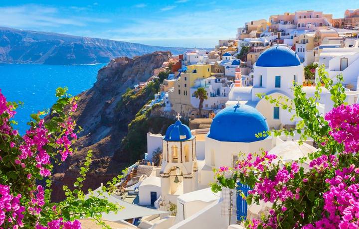 Santorini island, Greece. Oia town traditional white houses and churches with blue domes over the Caldera, Aegean sea. Santorini island, Greece. Oia town traditional white houses and churches with blue domes over the Caldera, Aegean sea.