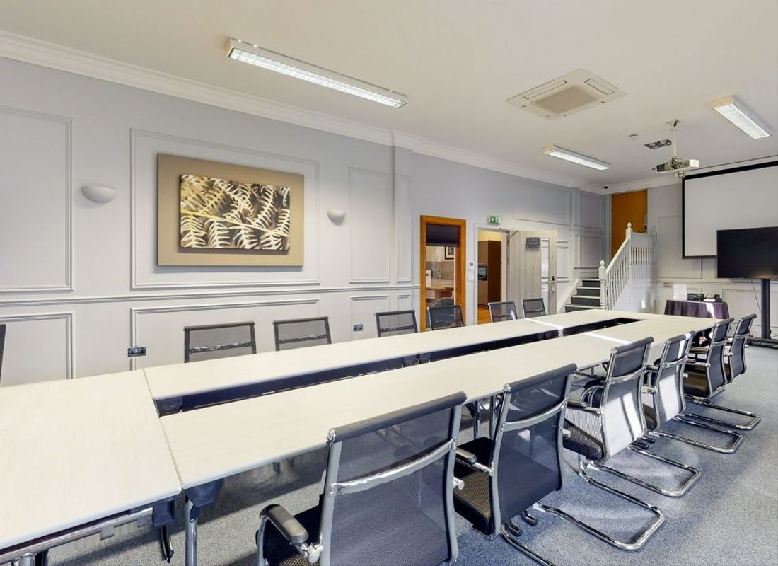 Large and spacious meeting room with long table and chair setup