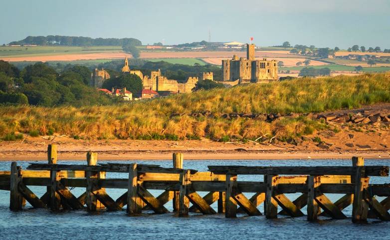 View of Warkworth castle from a distance in the early morning. Northumberland, United Kingdom