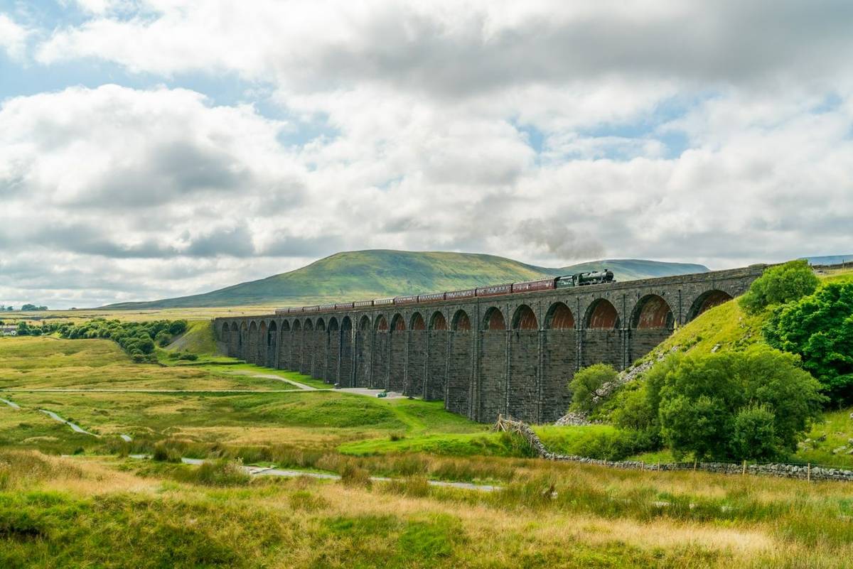 View of Ribblehead Viaduct (or Batty Moss Viaduct) with steam train in Yorkshire Dales, North Yorkshire, UK