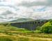View of Ribblehead Viaduct (or Batty Moss Viaduct) with steam train in Yorkshire Dales, North Yorkshire, UK