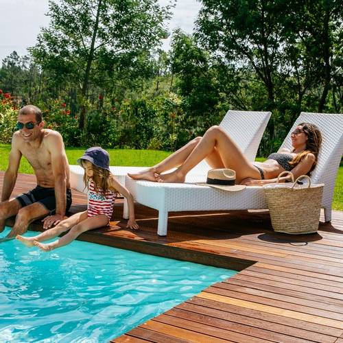 A family relaxing by the pool on a family wellness holiday