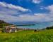 Image of Gorey Castle with Harbour, Grouville Bay calm sea and blue sky and clouds. Jersey, Channel Islands.